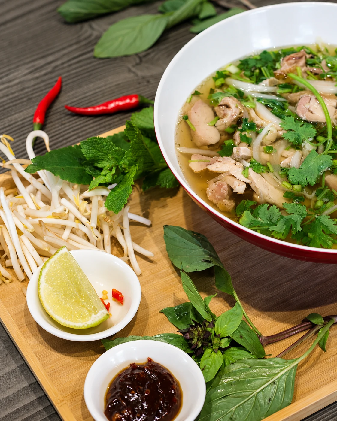 Phở du restaurant, accompagné de citron vert, de soja et d’herbes fraîches