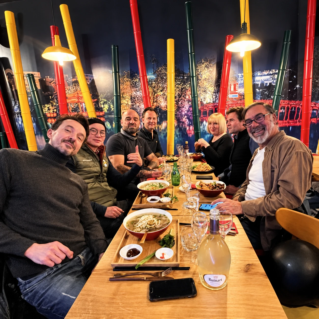 Une tablée dans la salle, entre les bambous rouges, jaunes et verts